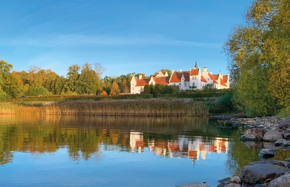 Ringsjöns strand med Bosjökloster och träden speglade i vattnet